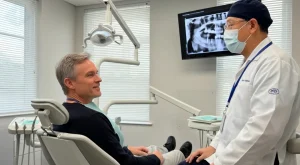 Paciente discutiendo el costo real y la durabilidad de los implantes dentales con el Dr. Aristo Carranza en Diseño de Sonrisas NJ, Westfield.